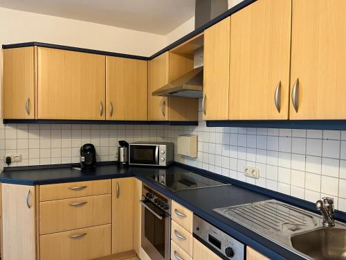 a kitchen with wooden cabinets and a black counter top at Ferienwohnung Seidl in Furth im Wald