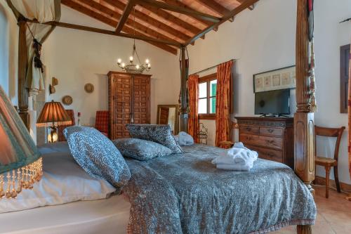 une chambre avec un grand lit et une télévision dans l'établissement Suite Xaloc im Es Llobets, à Llucmajor