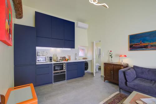 une cuisine avec des placards bleus et un canapé bleu dans l'établissement Appartement Mara Old Town - Happy Rentals, à Antibes
