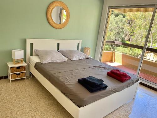 un lit dans une chambre avec une grande fenêtre dans l'établissement T3 vue mer piscine proche plage, à Bormes-les-Mimosas