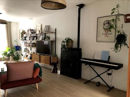 - un salon avec un piano et une chaise dans l'établissement Jolie maison de ville au calme, à Marcq-en-Barœul