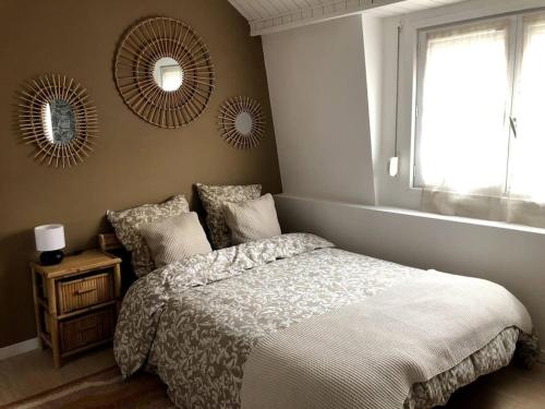 a bedroom with a bed and two mirrors on the wall at Jolie maison de ville au calme in Marcq-en-Baroeul