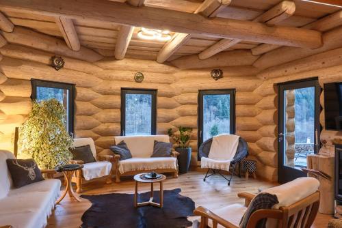 a living room with wooden walls and windows at RALPH Cabin- Apuseni Mountains, Transylvania in Bucium