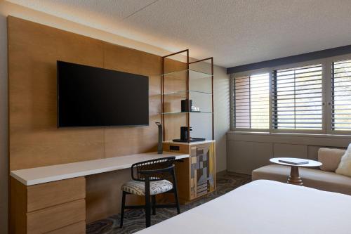 a hotel room with a desk with a television on a wall at Phoenix Marriott Resort Tempe at The Buttes in Tempe