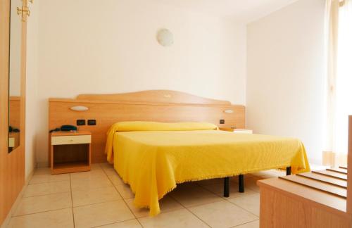 - une chambre avec un lit doté d'une couverture jaune dans l'établissement Motel Monterosa, à Vogogna