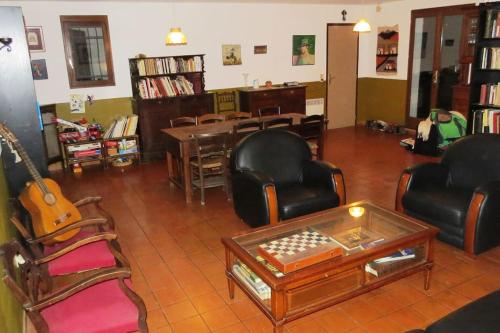 - un salon avec des chaises, une table et une guitare dans l'établissement Maison 90m2 avec grand parc au bord de la rivière, à Montredon-Labessonnié