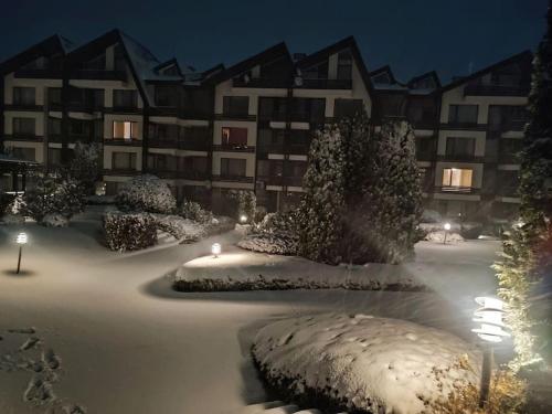 a snow covered parking lot in front of a building at 2 Bdr Garden Apt with Spa near Ski and Golf in Razlog