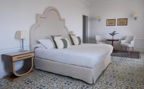 a bedroom with a large white bed and a table at La Medusa Hotel - Dimora di Charme in Castellammare di Stabia