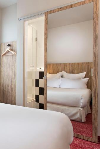 a hotel room with two beds and a shower at Libertel Gare Du Nord Suede in Paris