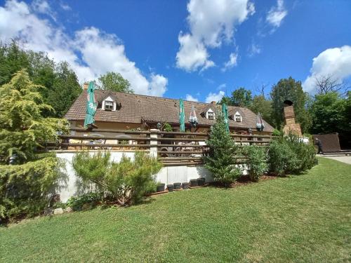 a house with a fence in a yard at Penzion Hájovna U Dubu in Karlštejn