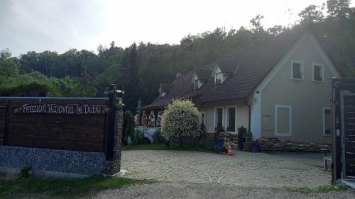 a house with a gate in front of it at Penzion Hájovna U Dubu in Karlštejn