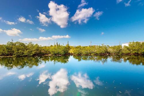 a body of water with trees and clouds in the sky at Beachside Fantasy in Big Pine Key