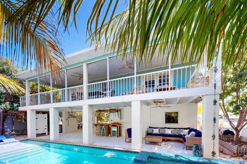 a villa with a swimming pool and a house at Beachside Fantasy in Big Pine Key