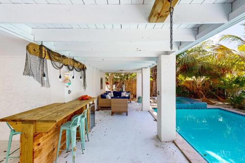 a patio with a table and chairs next to a swimming pool at Beachside Fantasy in Big Pine Key