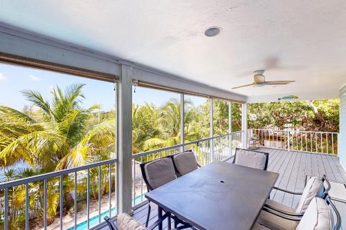 a patio with a table and chairs on a balcony at Beachside Fantasy in Big Pine Key