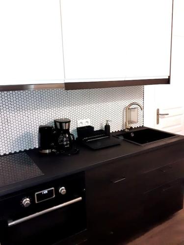 une cuisine avec un évier et un plan de travail dans l'établissement Studio atypique neuf Tourny hyper centre Bordeaux, à Bordeaux