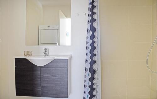 a bathroom with a sink and a mirror at Holiday Home Dyrefolden Ringkøbing Xii in Hee