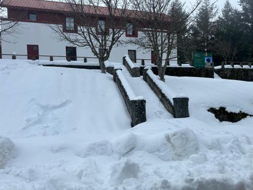 a pile of snow in front of a building at Golden Mountain, Nature House in Manteigas