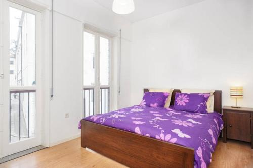 een slaapkamer met een bed met paarse lakens en ramen bij OPO Domus in Porto