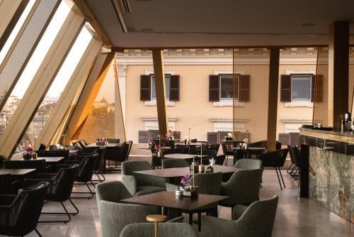 a restaurant with tables and chairs and large windows at The First Musica - Preferred Hotels & Resorts in Rome