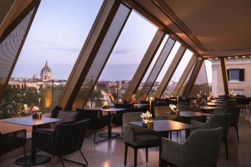 a restaurant with tables and chairs with a view of the vatican at The First Musica - Preferred Hotels & Resorts in Rome