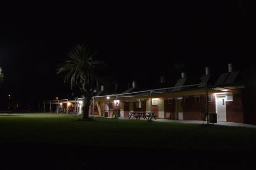 a group of buildings at night with a palm tree at בית ספר שדה חצבה in H̱aẕeva