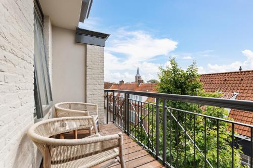 a balcony with two chairs and a view of the city at Hotel Bommelje in Domburg