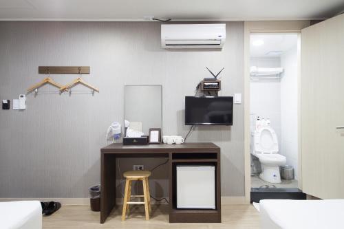 a bathroom with a desk with a tv and a toilet at K-Grand Hostel Gangnam1 in Seoul