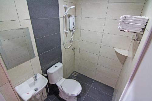 a small bathroom with a toilet and a shower at Thanks Hotel in Parit Buntar