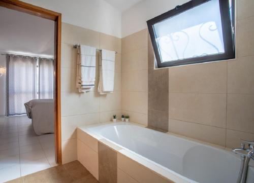 a bathroom with a tub and a tv on the wall at Carosim - Quiet location, close to beach, private in Poço Partido