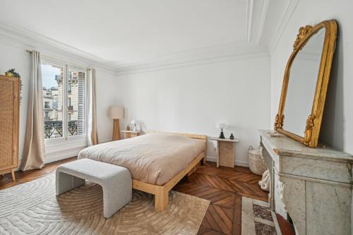 une chambre avec un lit et un miroir au mur dans l'établissement Duplex avec billard à côté de la Tour Eiffel !, à Paris
