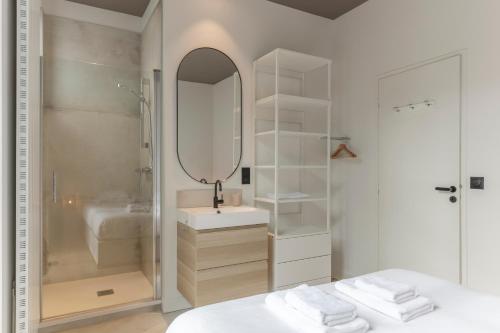 une salle de bain blanche avec un lavabo et un miroir dans l'établissement Superbe Maison avec Jardin - La Villa Paloise, à Pau