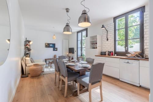 une cuisine et une salle à manger avec une table et des chaises dans l'établissement Superbe Maison avec Jardin - La Villa Paloise, à Pau