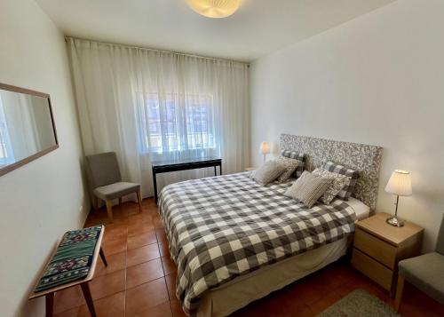 a bedroom with a bed with a checkered blanket at Carvoeiro terrace - Stay in the heart of Carvoeiro in Carvoeiro