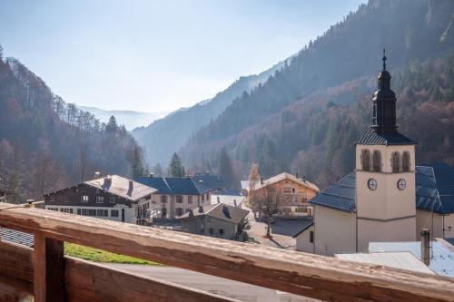 a view of a town with a clock tower at Le Petit Aravis - village et vue panoramique in La Giettaz