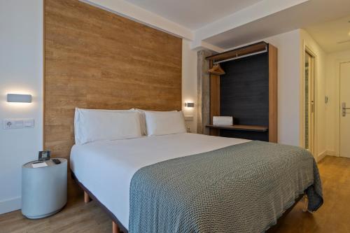 a bedroom with a large bed with a wooden headboard at Uma Suites Ondarreta in Donostia-San Sebastián