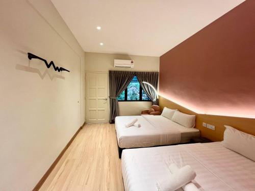 a hotel room with two beds and a window at Premium Kampung Villa with Jacuzzi 18pax 5BR in Kelebang Besar
