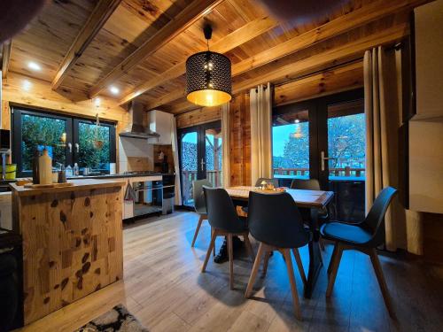 une cuisine et une salle à manger avec une table et des chaises dans l'établissement Le Chalet Aura et Jacuzzi, à Abreschviller