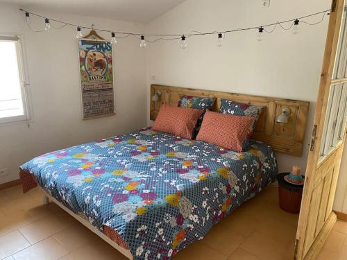 Un dormitorio con una cama con una colcha encima en Le Mazet du Village, en Arles