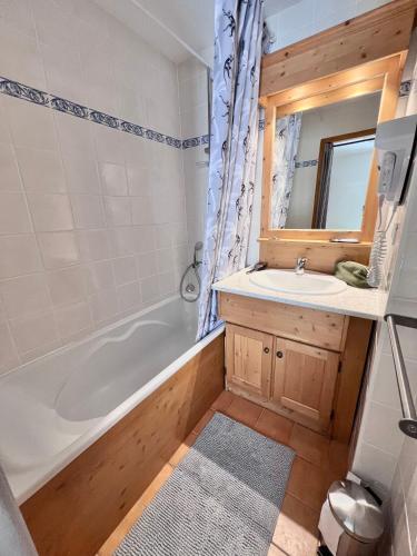 une salle de bain avec une baignoire et un lavabo dans l'établissement Appartement cosy 5-6p aux pieds des pistes 2 chambres 2 sdb, à Oz
