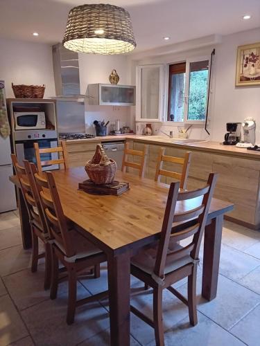 - une cuisine avec une table à manger en bois et des chaises dans l'établissement Cottage bergerie en pierres avec jacuzzi en corse 6 personnes, 3 chambres, à Coti-Chiavari