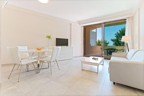 a living room with a table and a couch at The Residence Aparthotel in Podstrana
