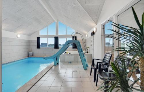 a indoor swimming pool with a slide in a house at 7 Bedroom Nice Home In Hvide Sande in Nørre Lyngvig