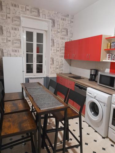 une cuisine avec une table et des chaises ainsi qu'un lave-linge dans l'établissement Sweet home, à Cholet