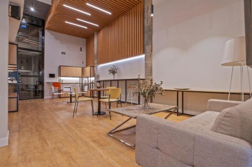 a living room with a couch and a table at Uma Suites Ondarreta in Donostia-San Sebastián
