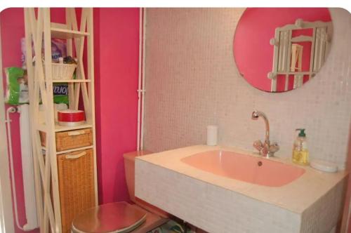 ein rosafarbenes Bad mit einem Waschbecken und einem Spiegel in der Unterkunft Nid de Corsaire, Vue Mer & Accès plage in Saint-Malo