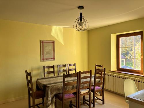 a dining room with a table and chairs at Gîte spacieux 8 personnes - Saint Joseph des Bruyères 1814 in Remiremont