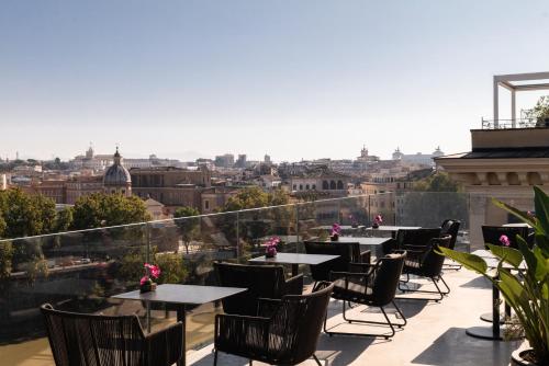 a balcony with tables and chairs and a view of the city at The First Musica - Preferred Hotels & Resorts in Rome