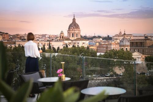 a woman standing on a roof looking at a city at The First Musica - Preferred Hotels & Resorts in Rome