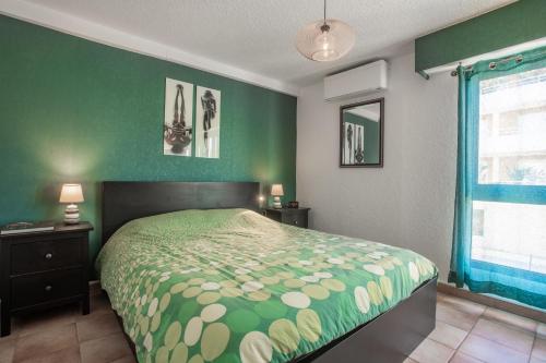 a bedroom with a bed and a green wall at La Favière proche de la plage in Bormes-les-Mimosas